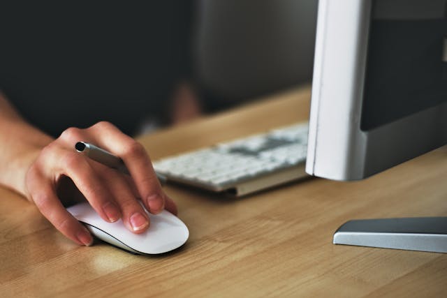 person using a mouse and computer